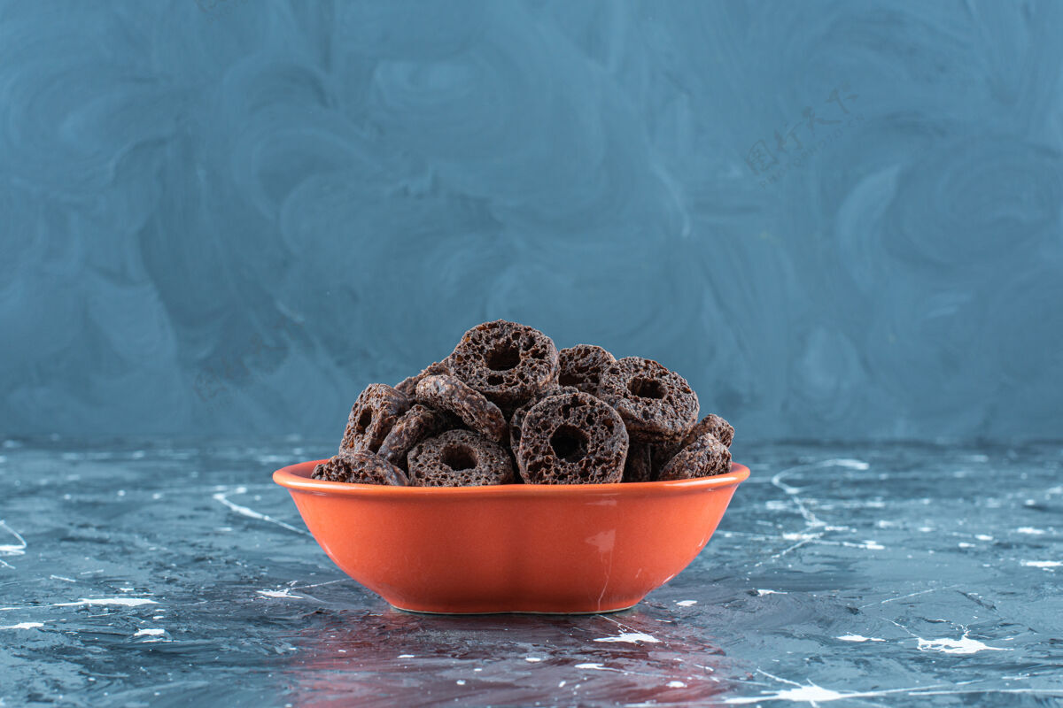 碗在大理石背景上 在碗里放一些涂有巧克力的玉米圈美味玉米片牙套