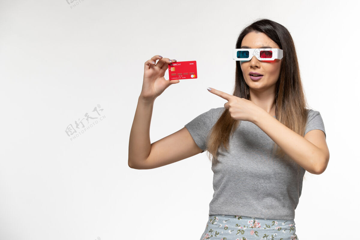 遥远正面图：戴着d型太阳镜手持银行卡的年轻女性 浅白色表面性感电影太阳镜