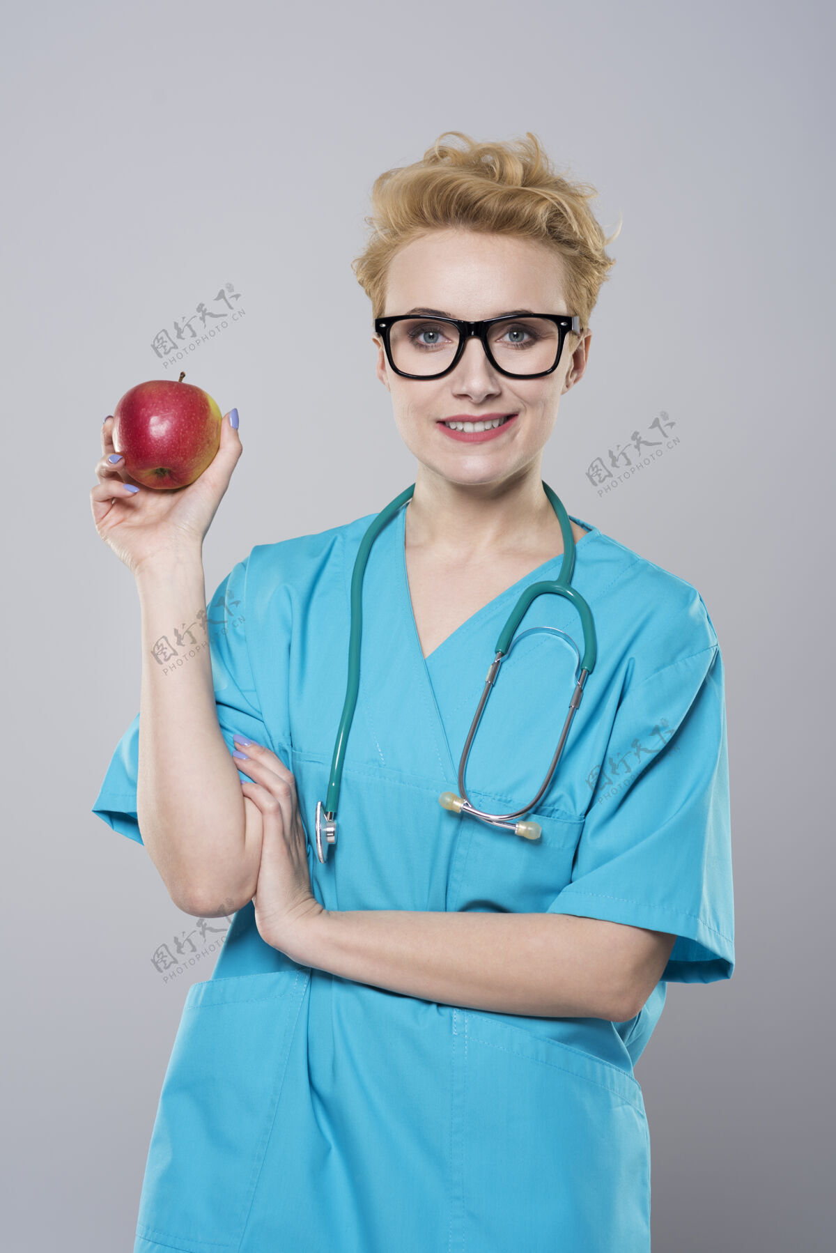 医护人员拿着苹果的女牙医肖像持有外科医生
