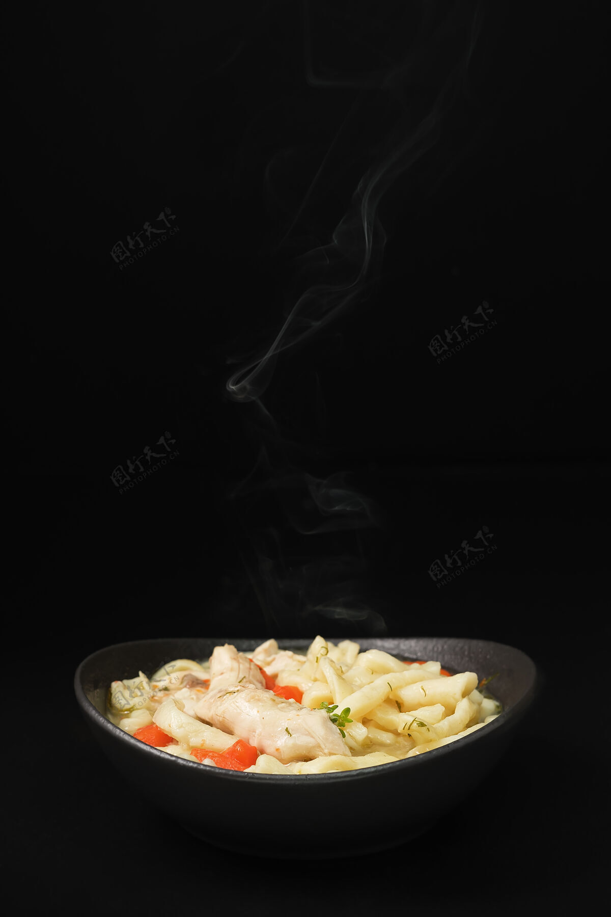 蒸汽选择性地集中在自制的辣味鸡汤面上 用蔬菜和香料放在碗里 特写 深色背景泰式热鸡肉
