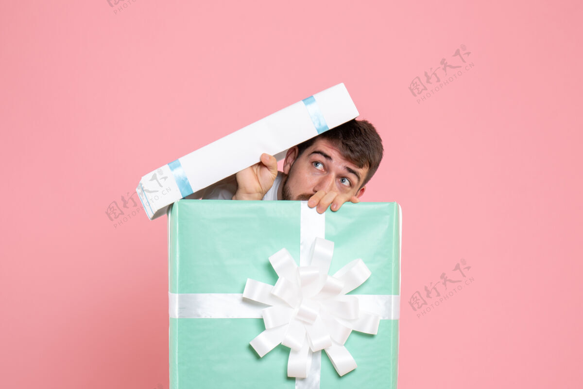 睡衣正面图年轻男性试图隐藏在礼物盒内的粉红色圣诞色情感睡衣派对人类游戏颜色礼物年轻男性