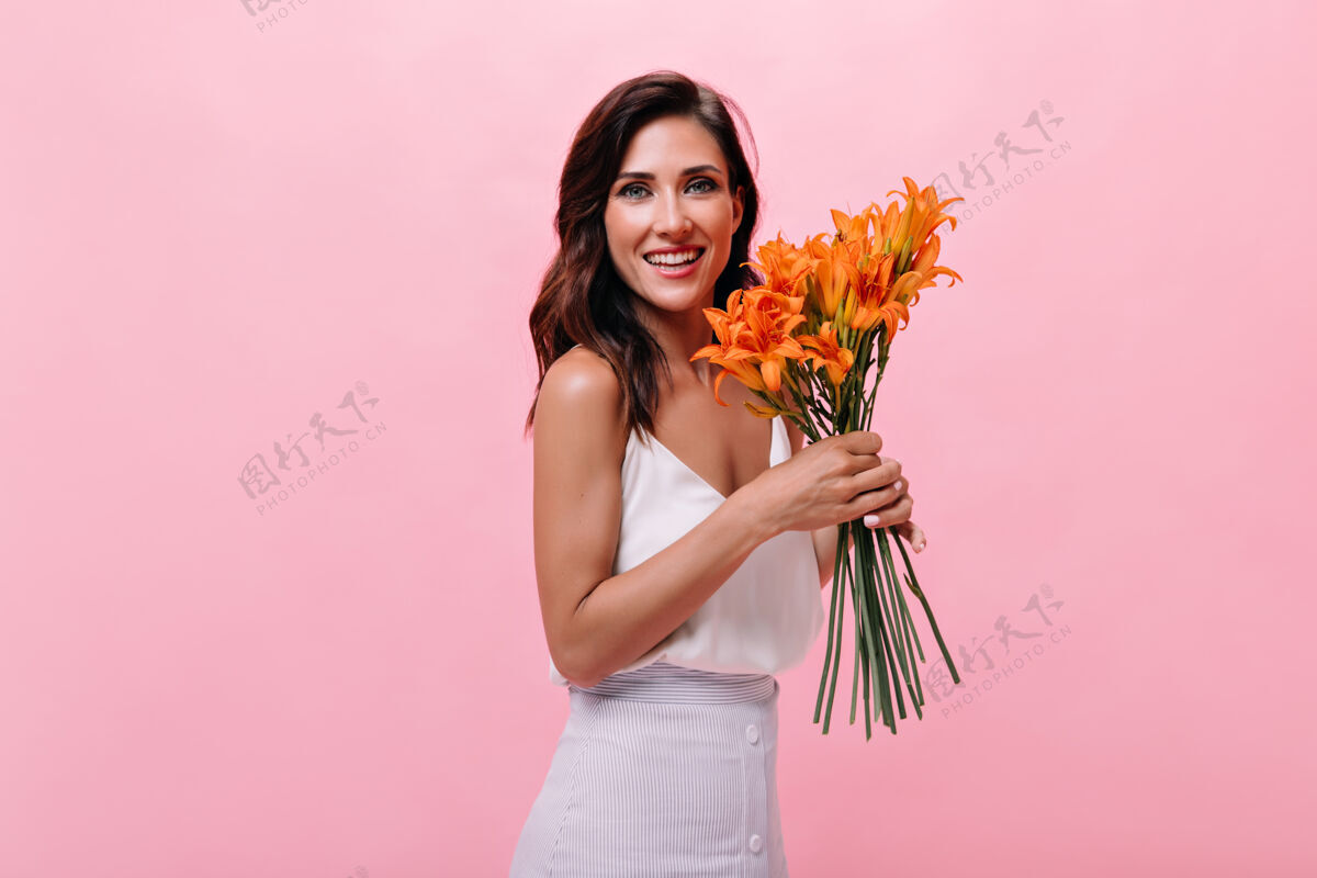 Swoosh身着白色服装的女士面带微笑 手里拿着一束鲜花美丽的女士在孤立的背景下摆出可爱的桔黄色花朵女性花休闲