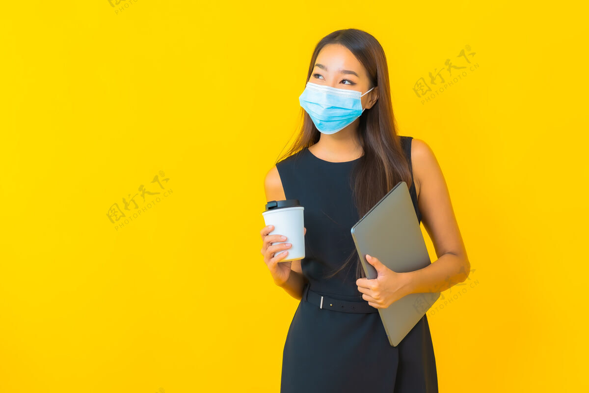 病人肖像美丽的年轻亚洲女商人戴着口罩用笔记本电脑保护covid19麻烦女性在线