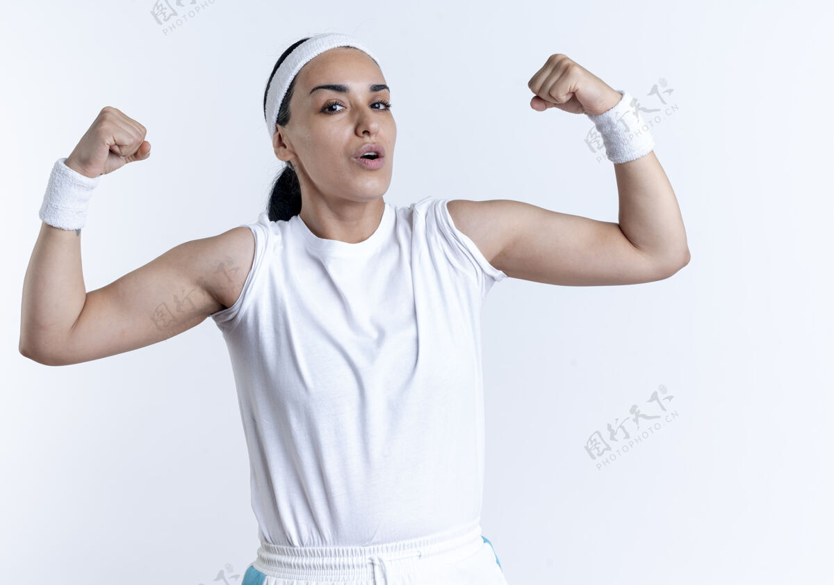 腕带年轻自信的高加索运动女性戴着头带和腕带紧张的二头肌隔离在白色空间与复制空间复制紧张年轻