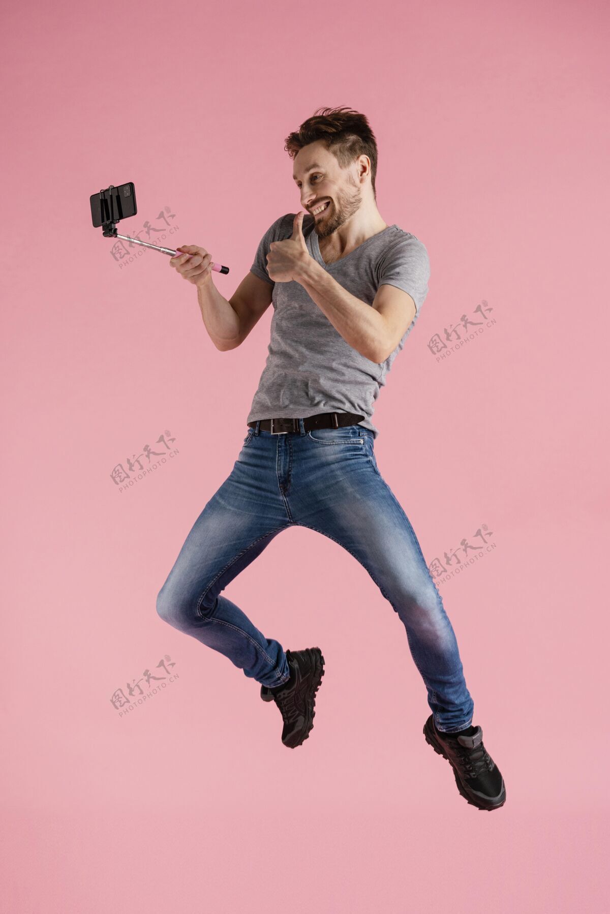 科技用自拍棒跳的人肖像男性姿势