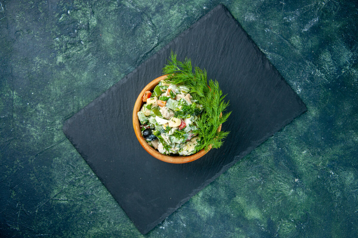 顶部顶视图蔬菜沙拉与绿色在深蓝色背景上的小锅里蔬菜景观蛋黄酱