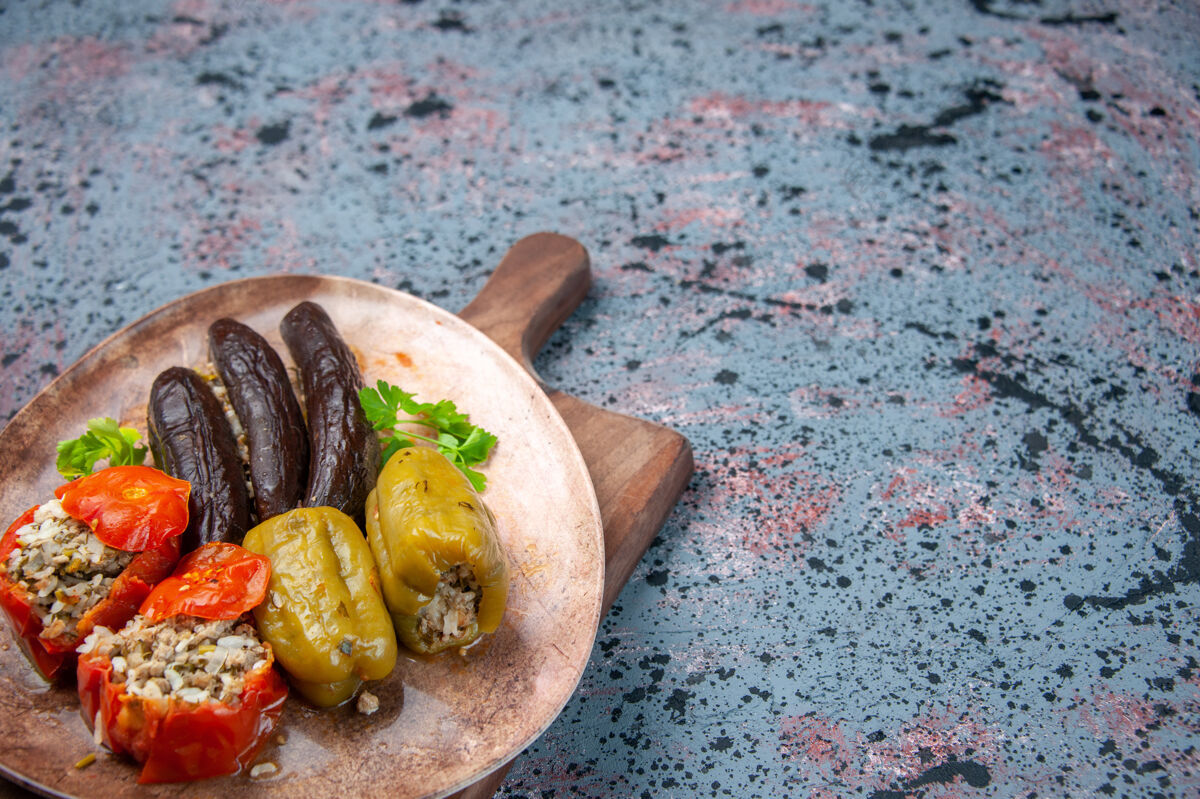 蔬菜前视图茄子与煮熟的西红柿和甜椒与肉末填充蓝色背景多尔玛背景晚餐前面