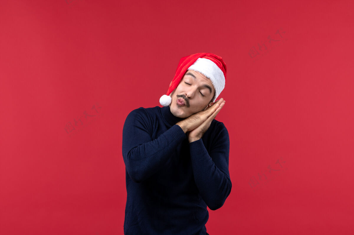 红色前视图年轻男性试图在红色背景上睡觉肖像头圣诞