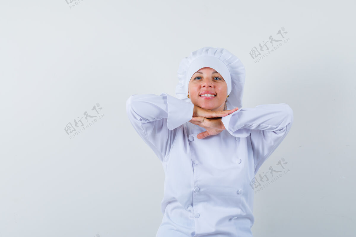 时尚穿着白色制服的女厨师 手放在下巴下面 看起来很可爱眼睛优雅时尚