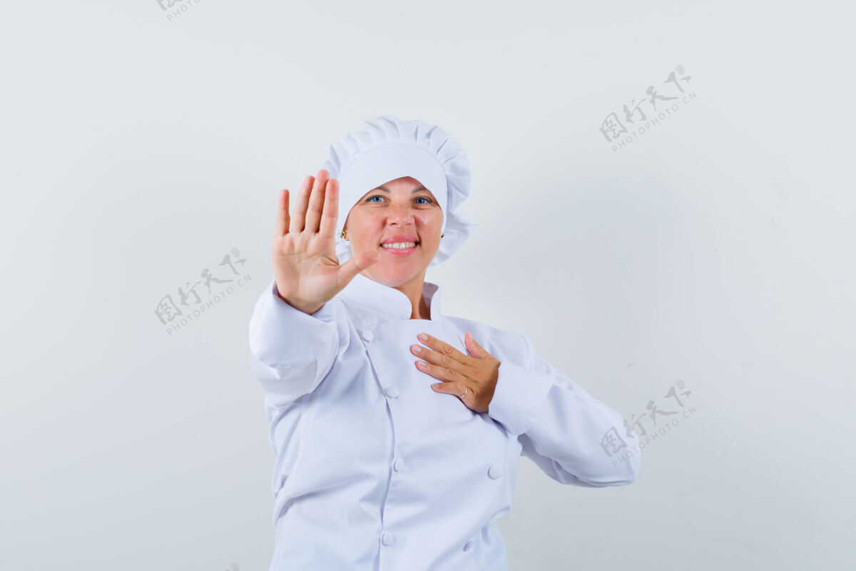 可爱一位身穿白色制服的女厨师展示着停下来的姿势 看上去很自信制服厨师显示