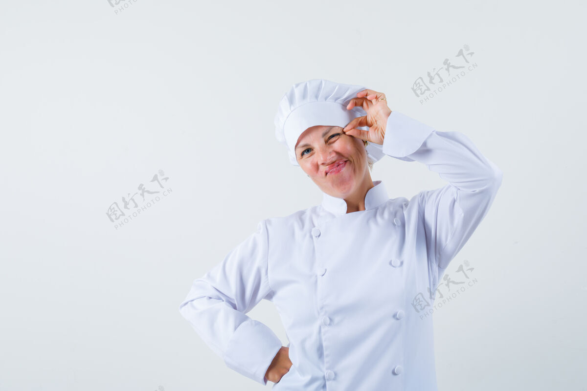 时尚一个穿着白色制服的女厨师捏着她的眼皮 看起来很奇怪时尚眼皮魅力