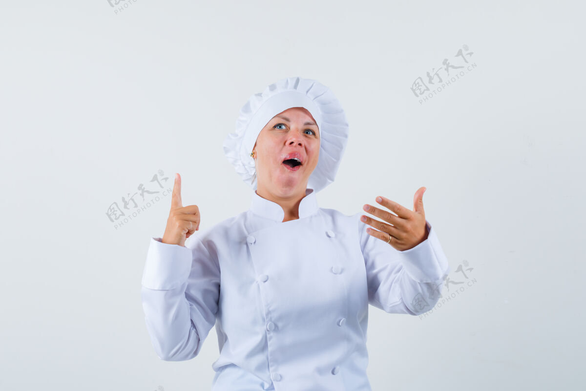 时尚穿着白色制服的女厨师在菜单上摆出一副挑选食物的姿势粉色乐趣年轻