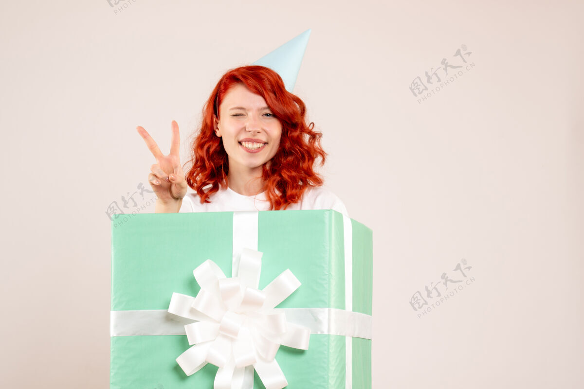 礼物前视女青年在白色地板上赠送圣诞照片感慨新年情感成人礼物