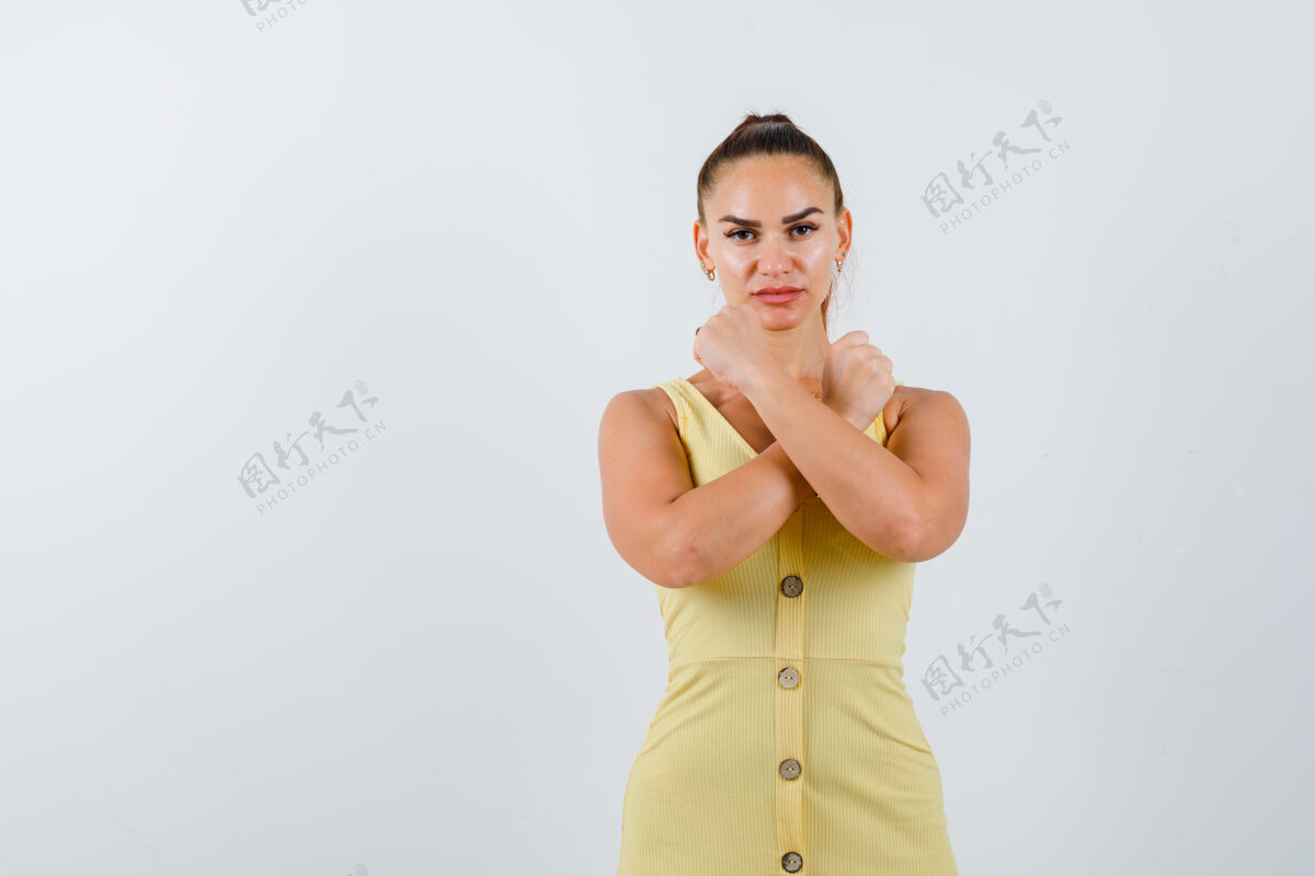 时尚身着黄色连衣裙 表情严肃的年轻女士的画像手势年轻发型