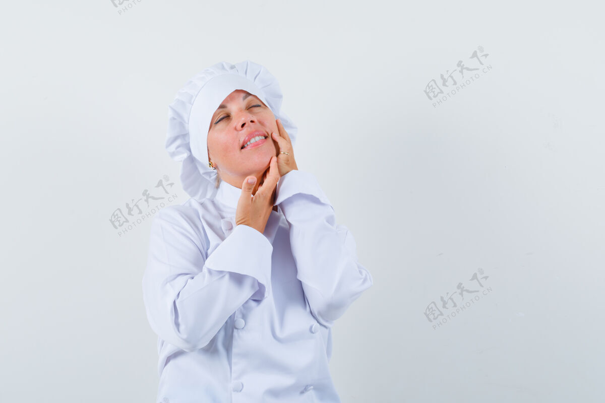 欢呼穿着白色制服的女厨师抚摸着脸颊上的皮肤 看起来很优雅优雅肖像模特