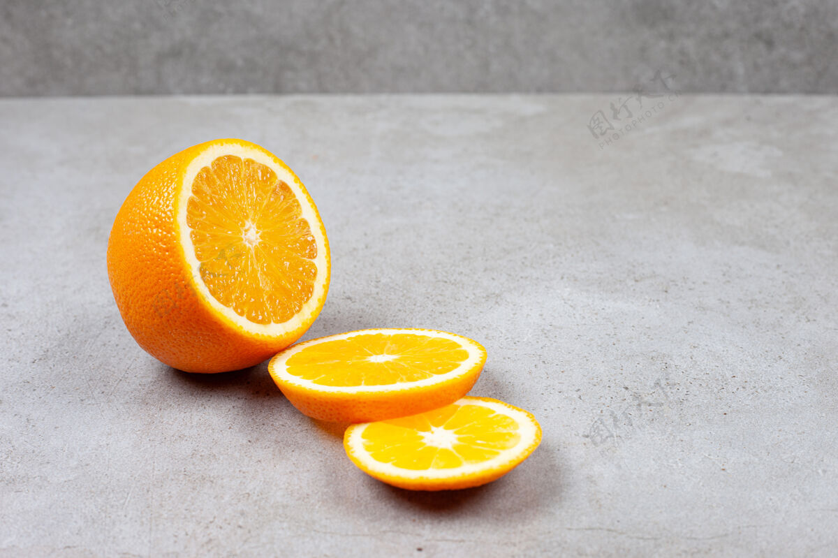 生的灰色桌子上的橘子切片特写照片部分整个黄色