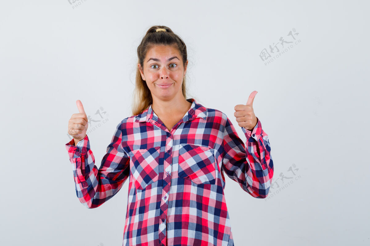 视图穿着格子衬衫的年轻女士竖起了大拇指 看上去很快乐正视图深褐色头女孩
