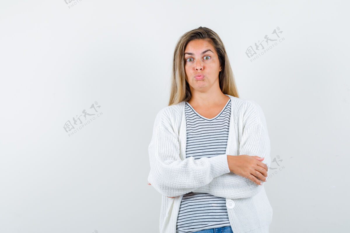成人年轻女士交叉双臂站着 撅着嘴 穿着t恤衫 夹克衫 面带困惑的前视图女士嘴唇自然