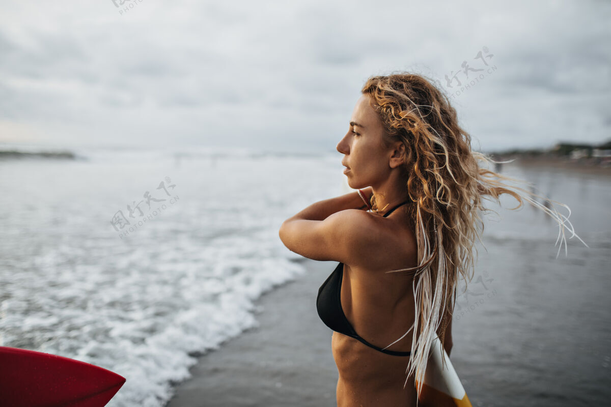 海洋金色卷发的女孩看着大海封闭年轻大海