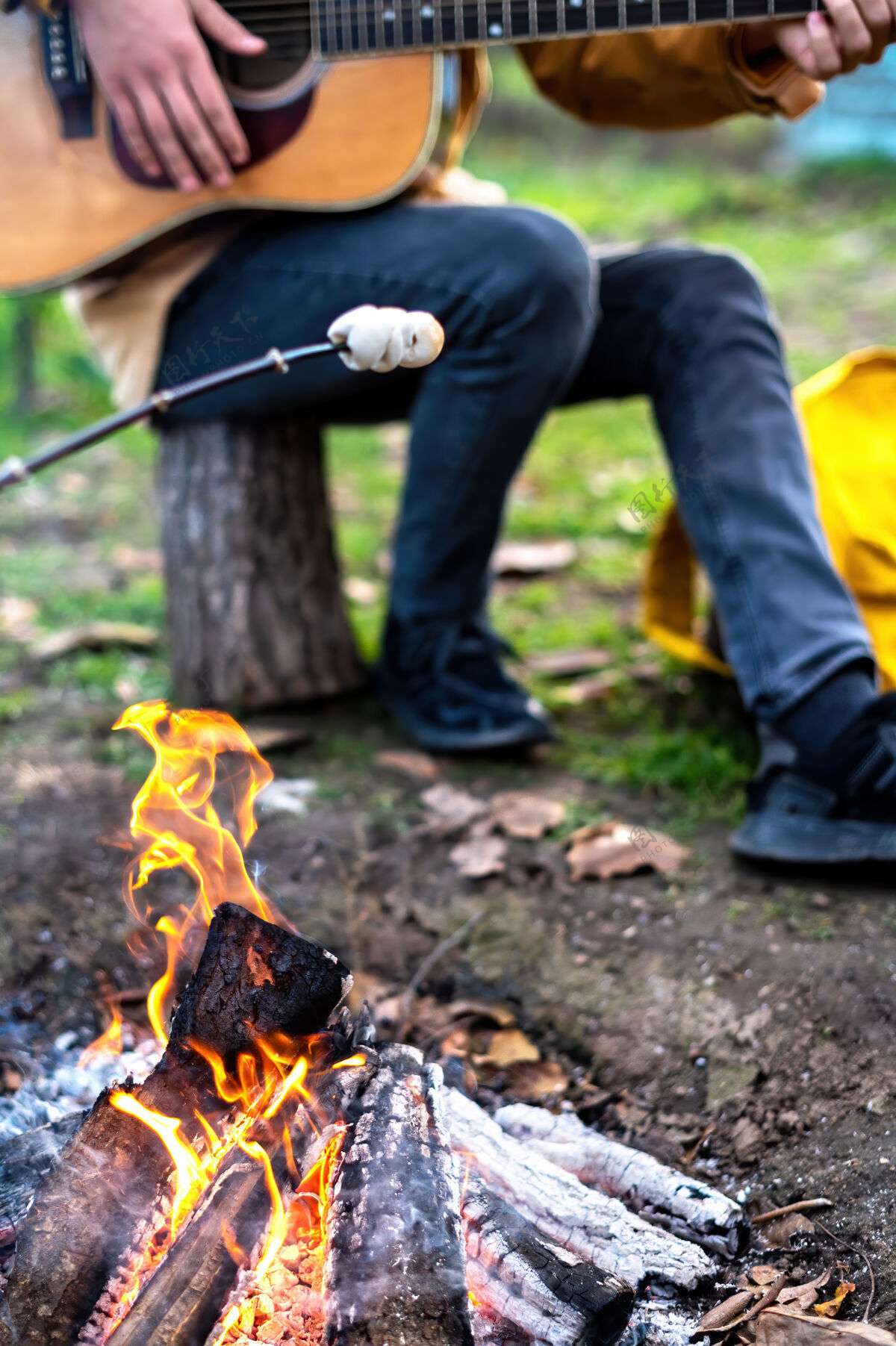 冷有篝火的野餐 一个人在弹吉他 另一个人在火上煮棉花糖温暖棉花糖烤