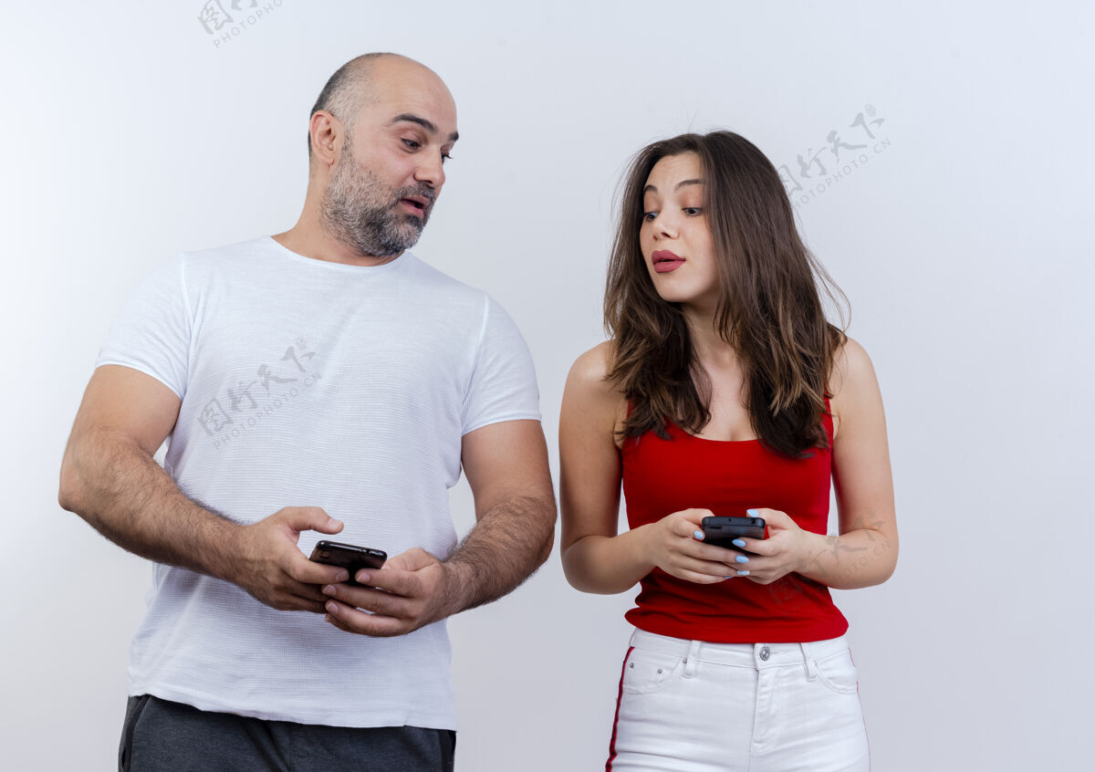 手机令人印象深刻的成年夫妇都拿着手机 看着对方的手机印象成人抱着