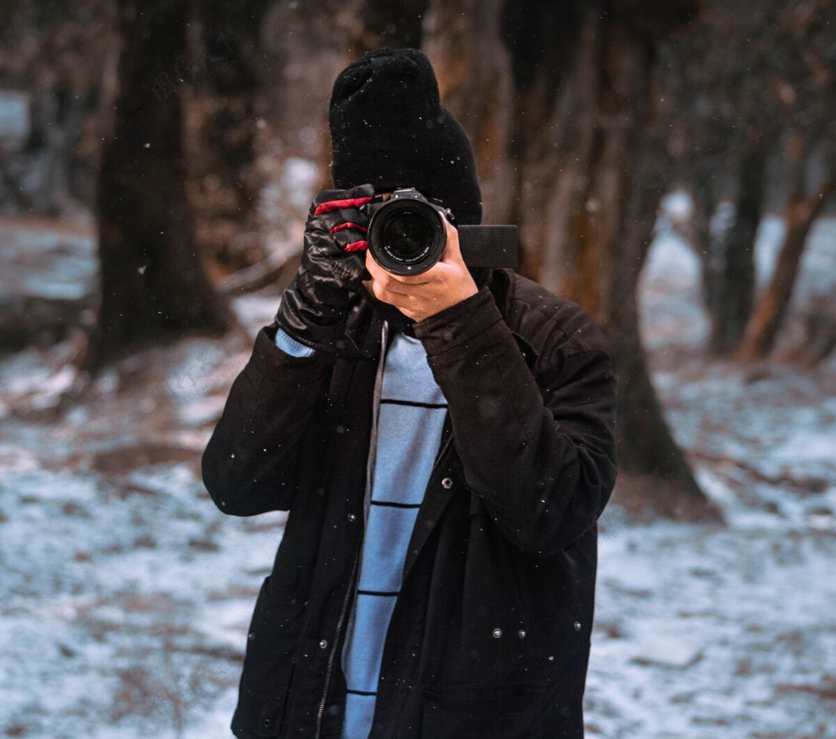 帽子在森林里捕捉冬天的男摄影师雪光人
