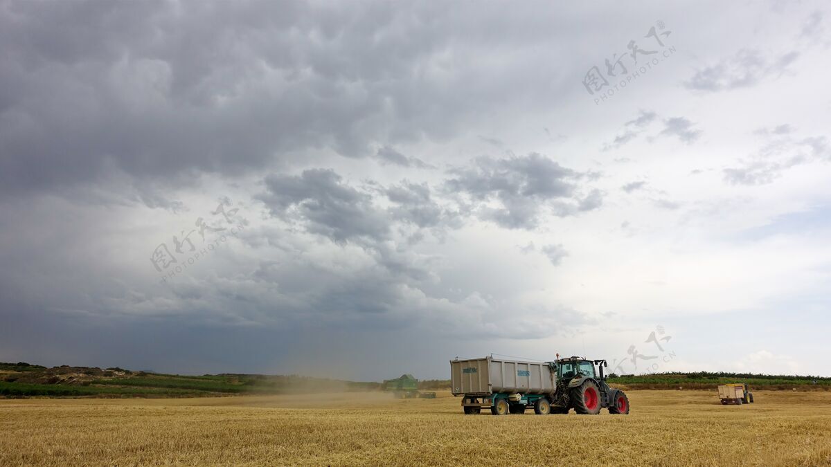 卡车在多云的天气里 卡车在田里收割户外草地草