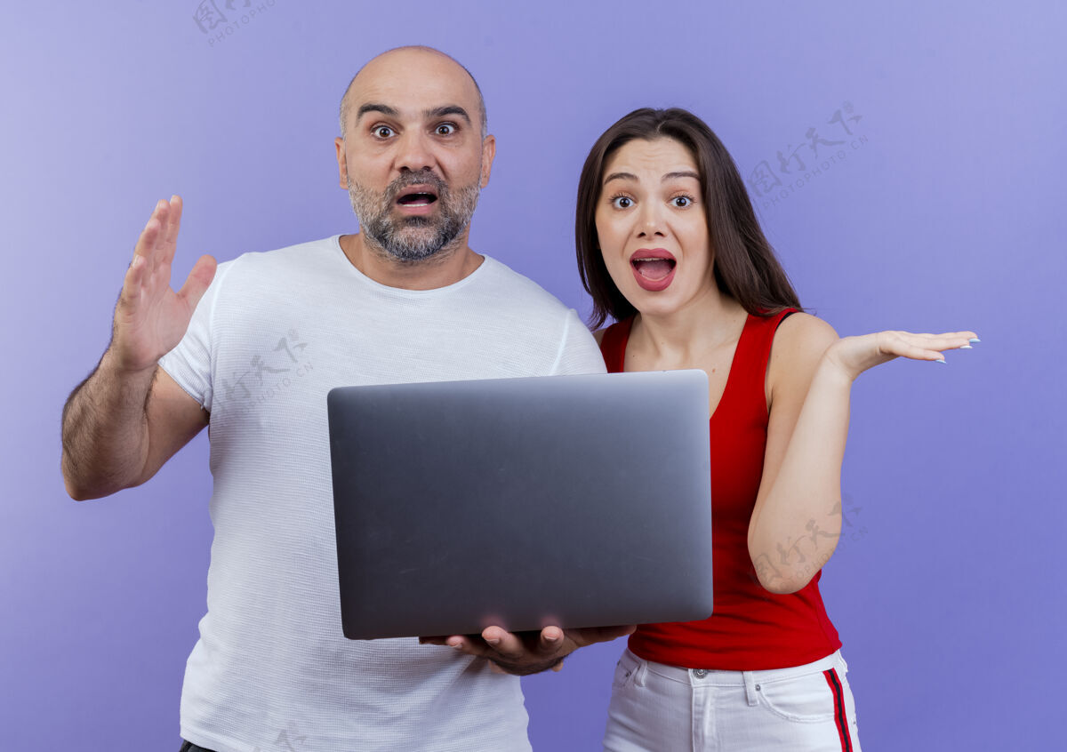看令人印象深刻的成人夫妇看着手提电脑显示空手显示笔记本电脑情侣
