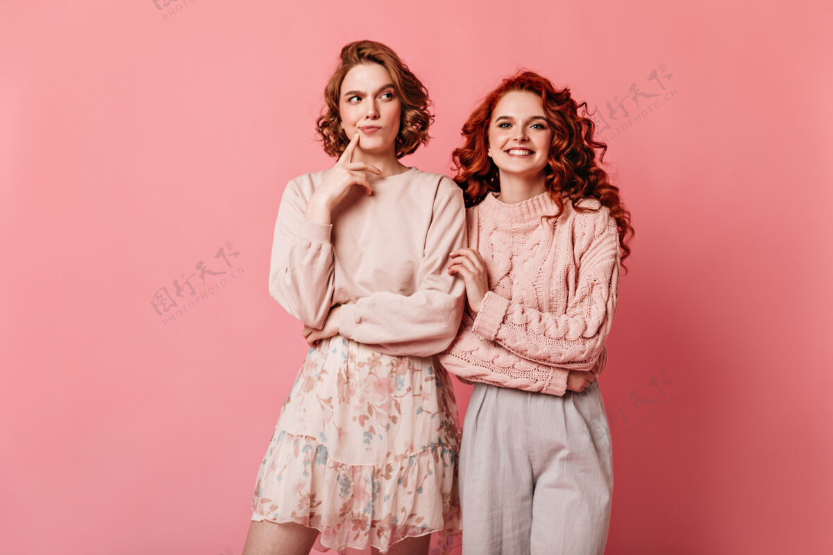 情绪两个穿着浪漫服装的朋友在一起合影在粉色背景上 可以看到令人惊叹的白人女孩的正面照片时尚姜黄色女人
