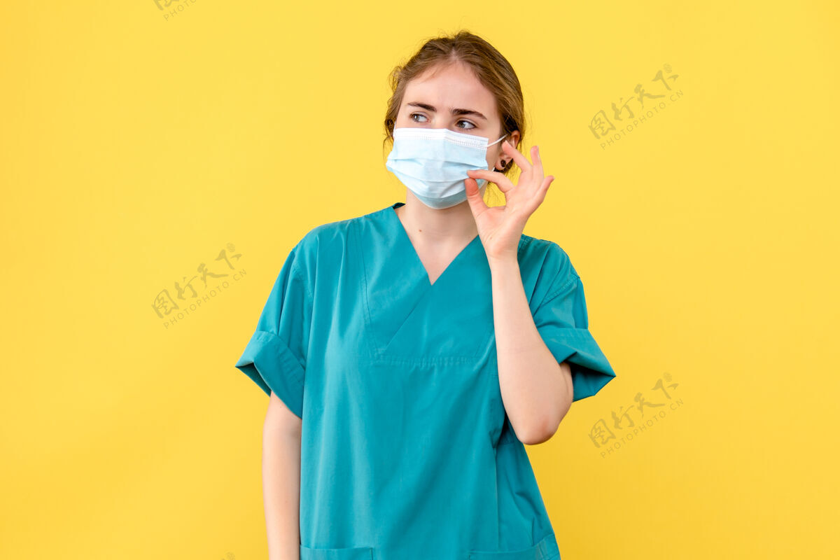 成人正面图黄色背景上戴无菌口罩的女医生医院健康病毒-大流行氧气面罩人大流行
