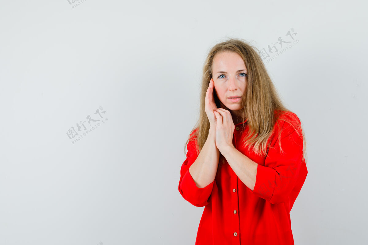健康穿着红衬衫的金发女士抚摸着脸颊上的皮肤 看起来很优雅优雅淑女触摸