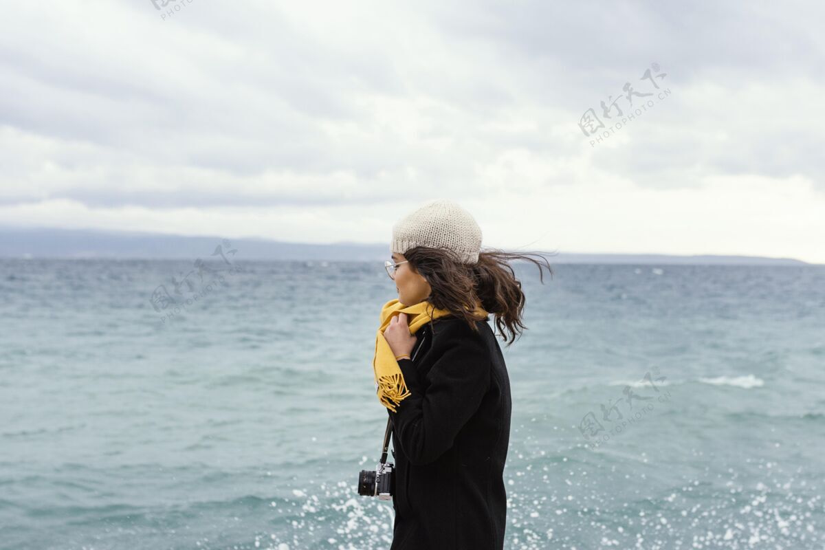 模特带着相机的年轻美女年轻围巾姿势