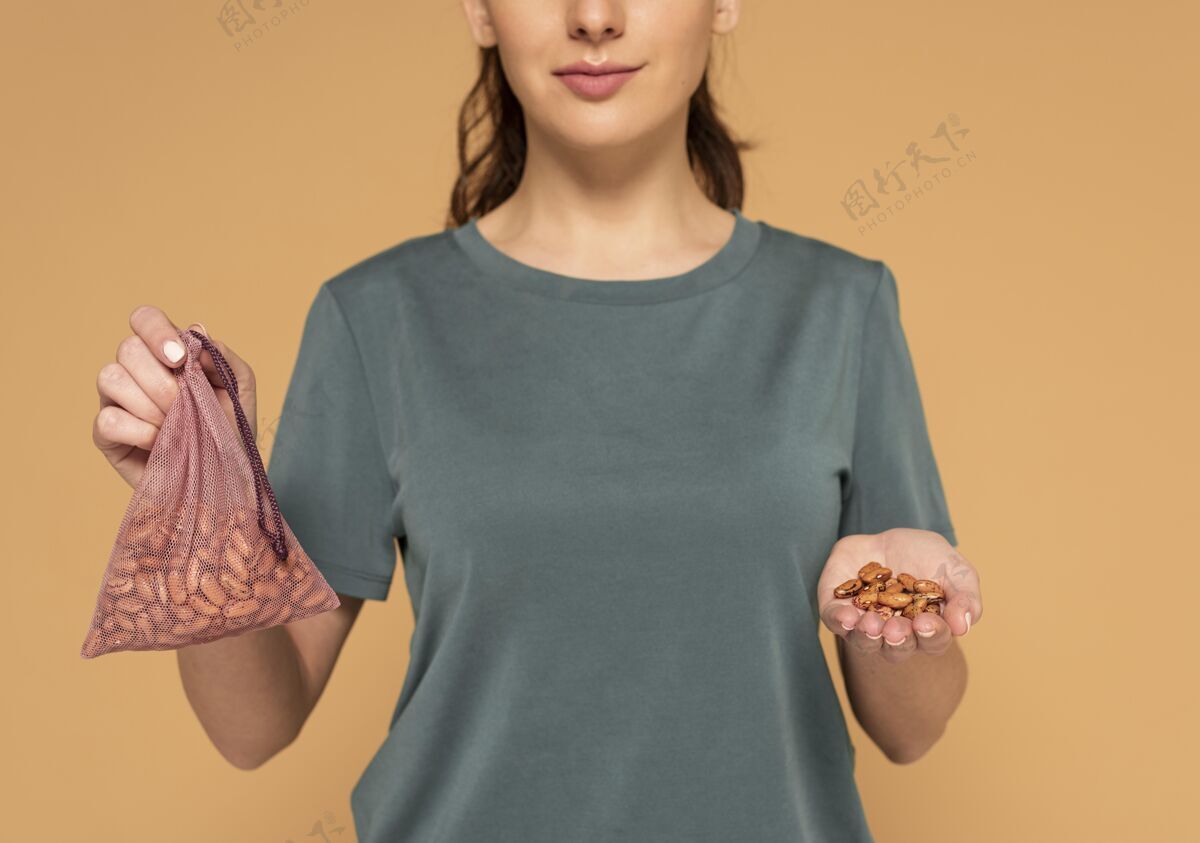女人拿着装豆子的龟袋的女人零浪费回收豆子