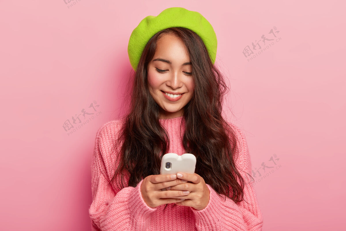 人快乐的年轻黑发韩国女子手持现代手机 将自己的照片发给男友 看搞笑通知电子肖像短信