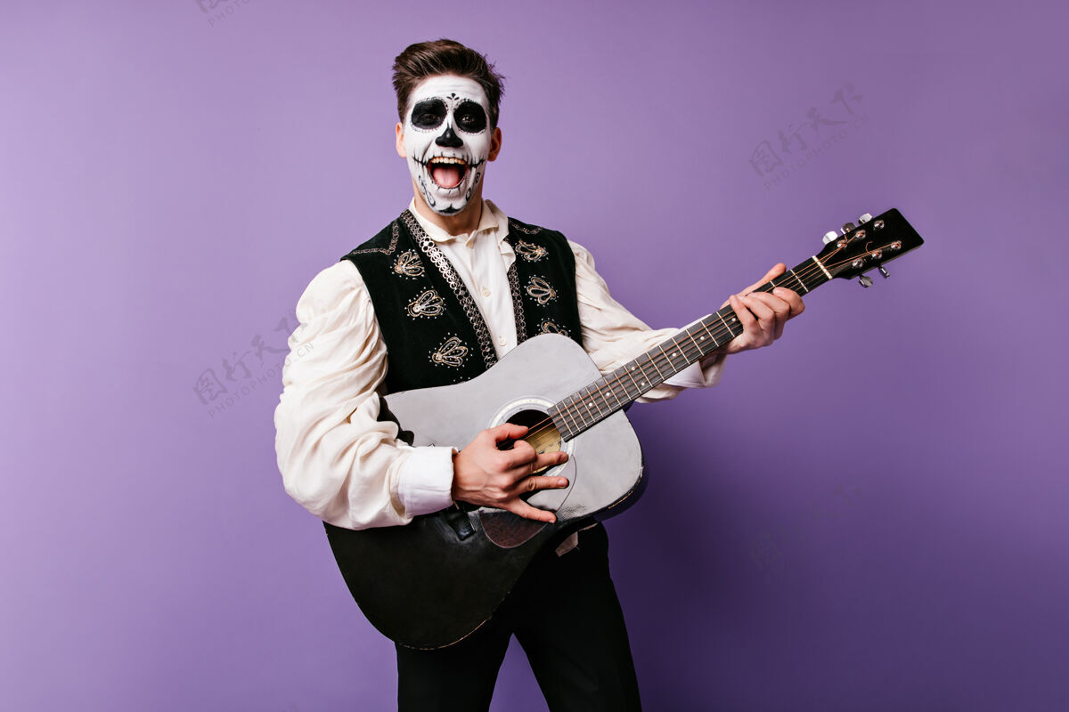恐怖身着墨西哥传统服装的乐观男人唱着小夜曲手拿吉他的感性男人的快照死亡骷髅服装