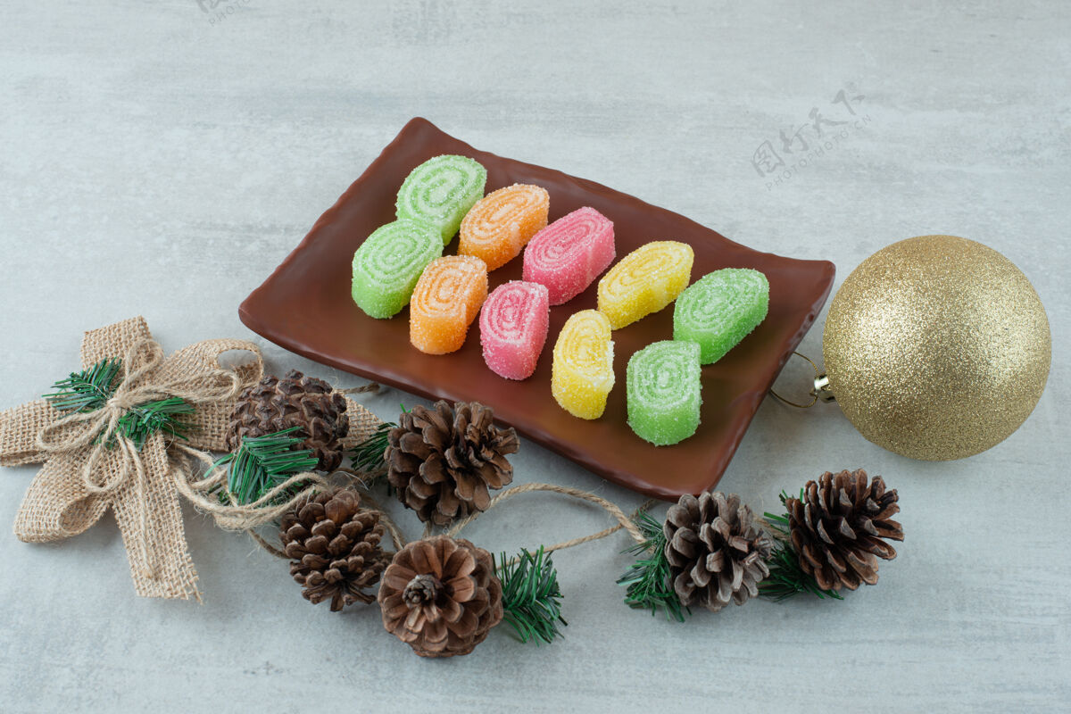 吃一个盘子里满是马尔代夫和大圣诞球的白色背景高质量的照片松果可口果酱
