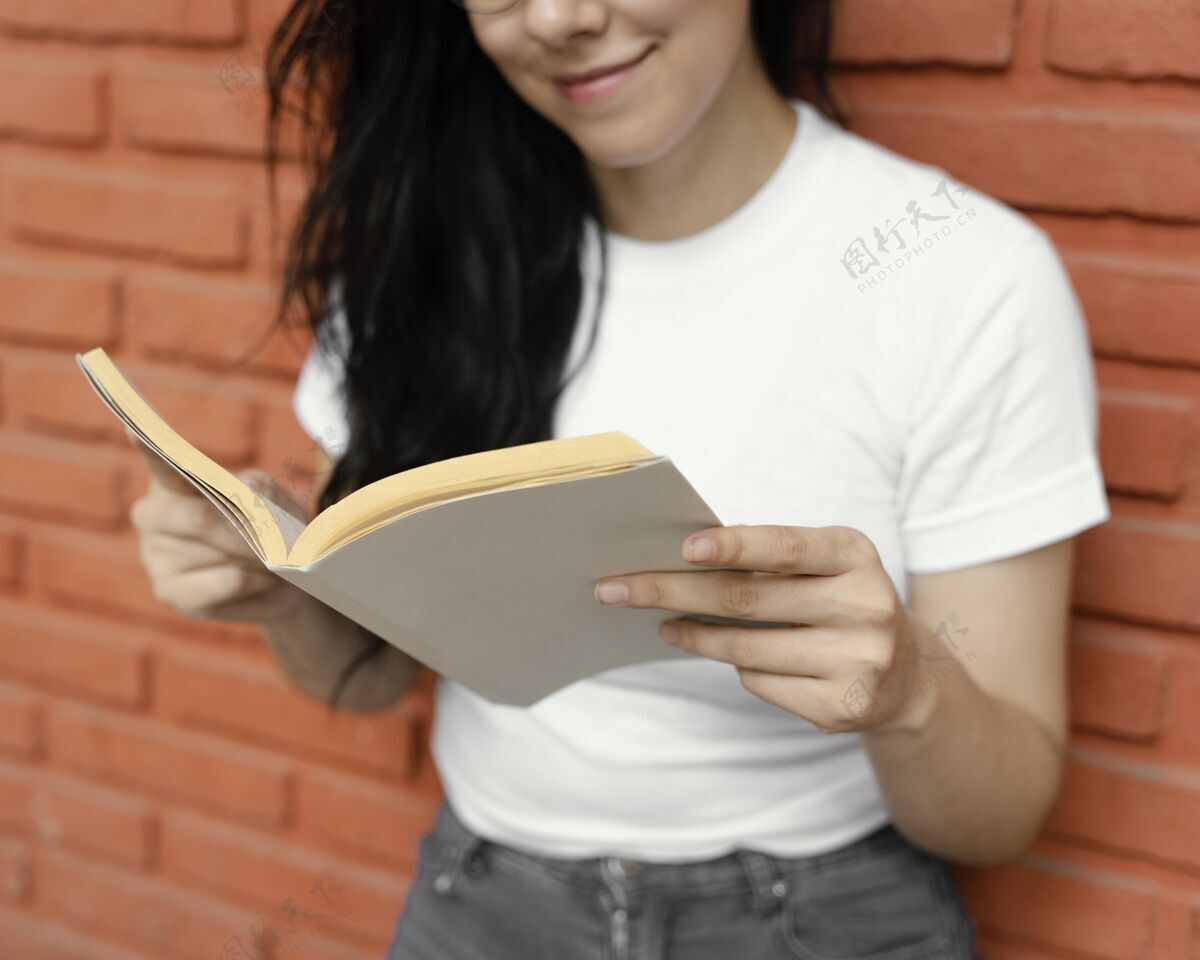 创造性年轻女子在户外读一本有趣的书世界读书日学习阅读