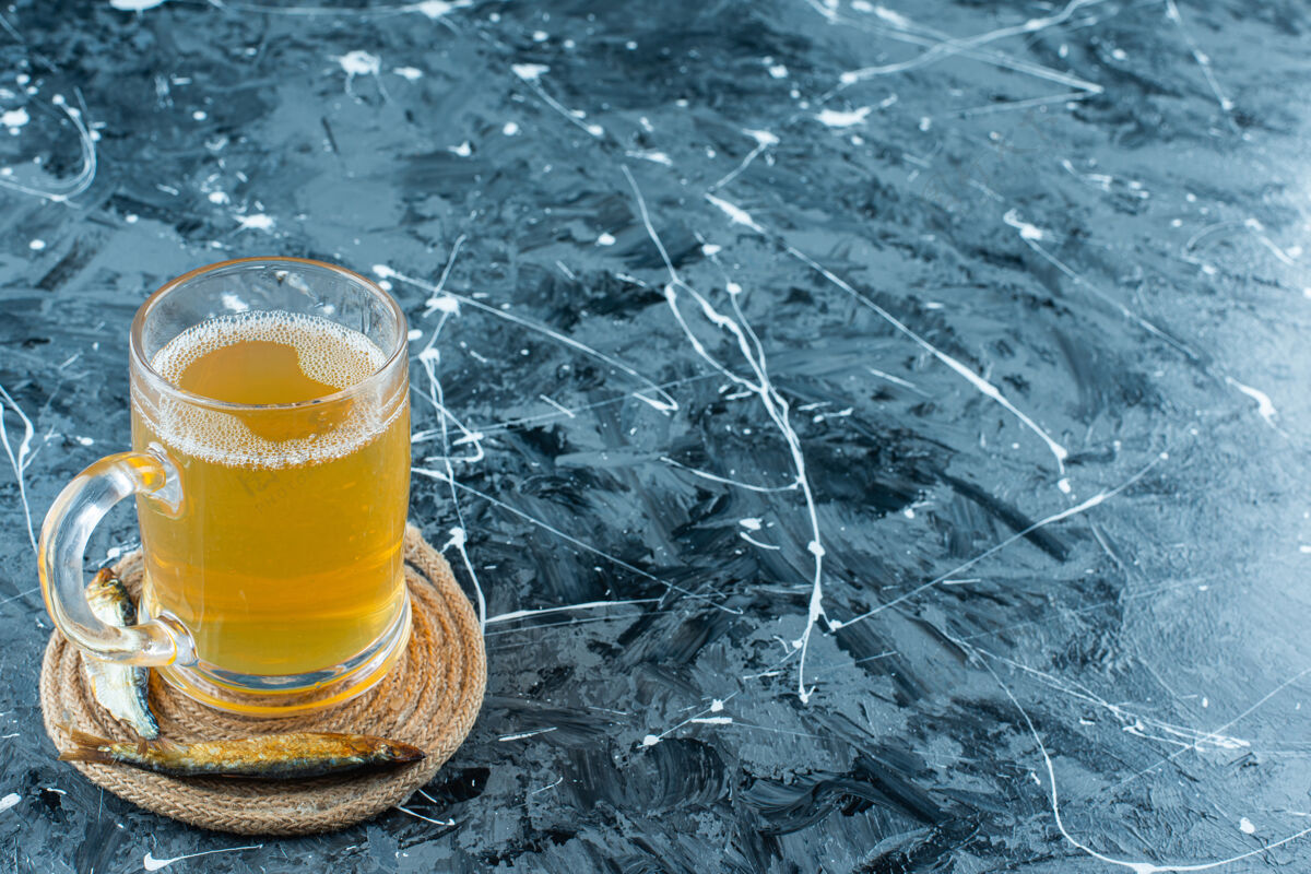 泡泡一杯啤酒和一杯鱼放在蓝色的三角架上啤酒酒精滴水
