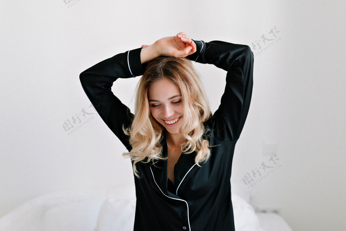 女孩在现代公寓里 穿着黑色睡衣的迷人 兴奋 可爱的女孩早晨醒来时的照片幸福房间放松