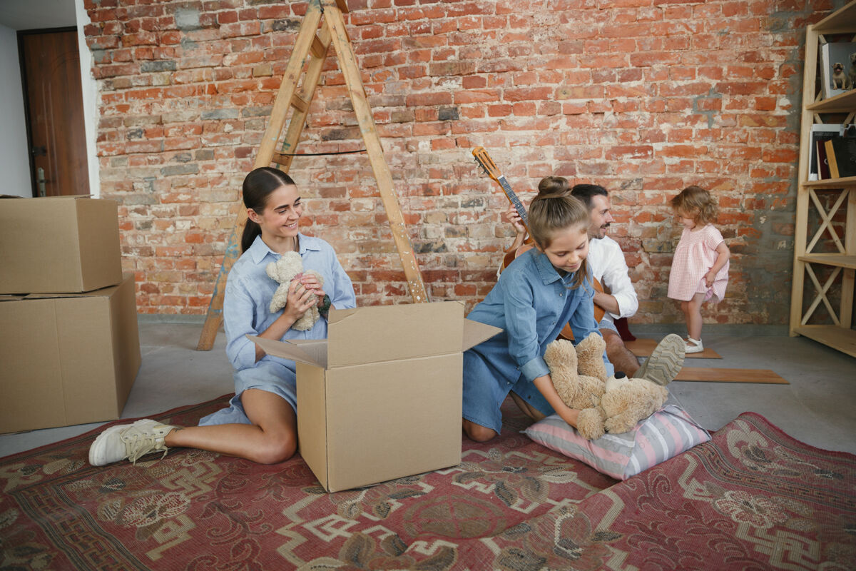 打开包装新生活成年家庭搬进新房子或公寓配偶和孩子看起来快乐而自信暂停城市家庭