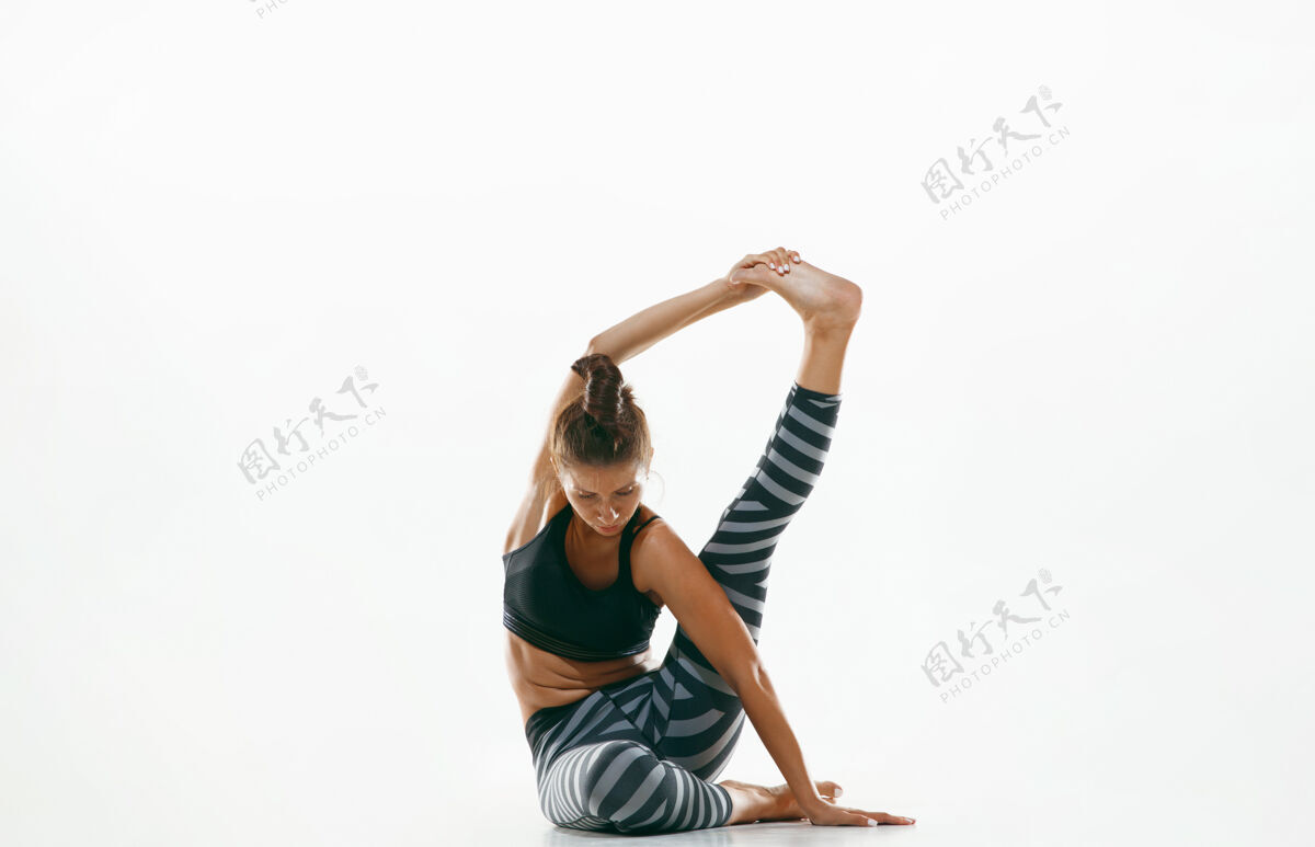 课程在运动空间练习瑜伽的年轻女性平衡练习运动员