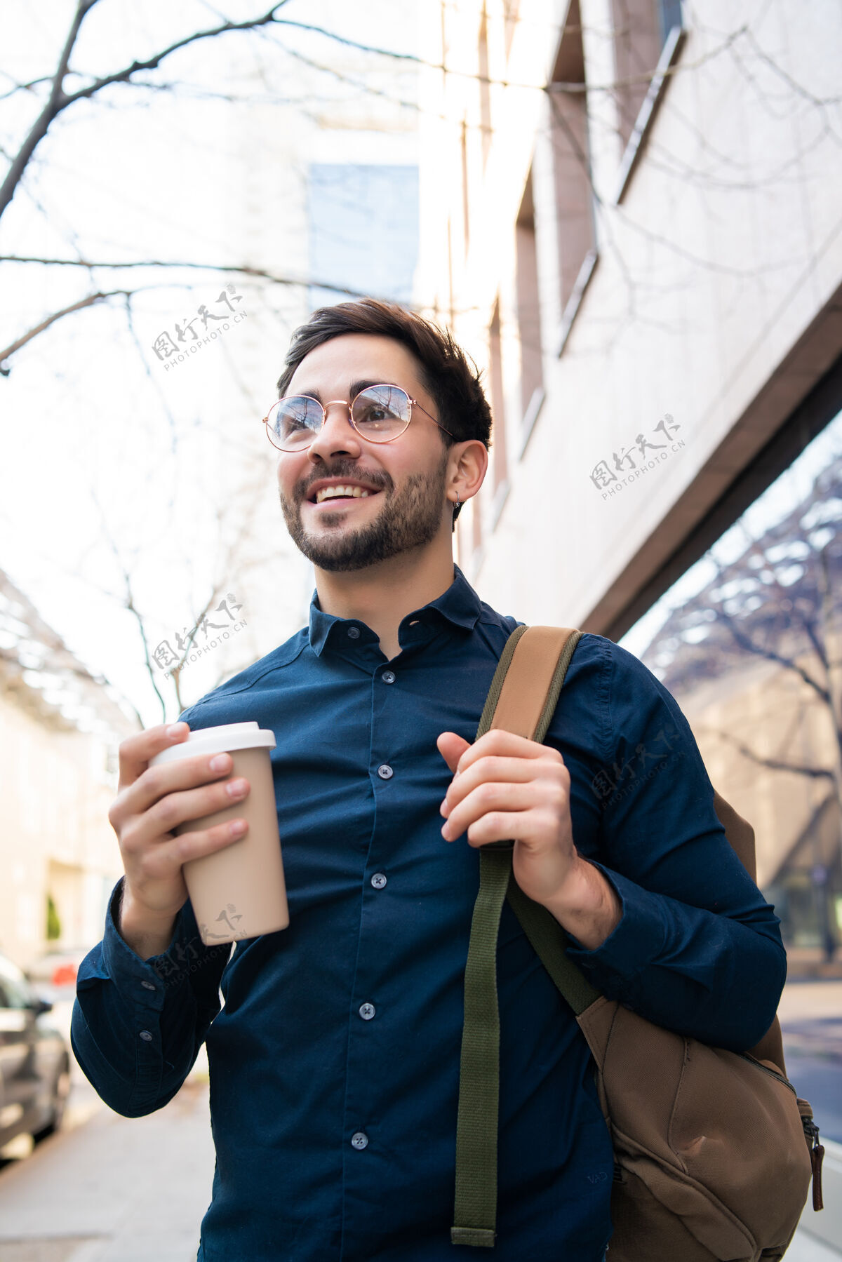 咖啡杯年轻人拿着一杯咖啡在街上走在户外的肖像城市和生活方式的概念人饮料城市
