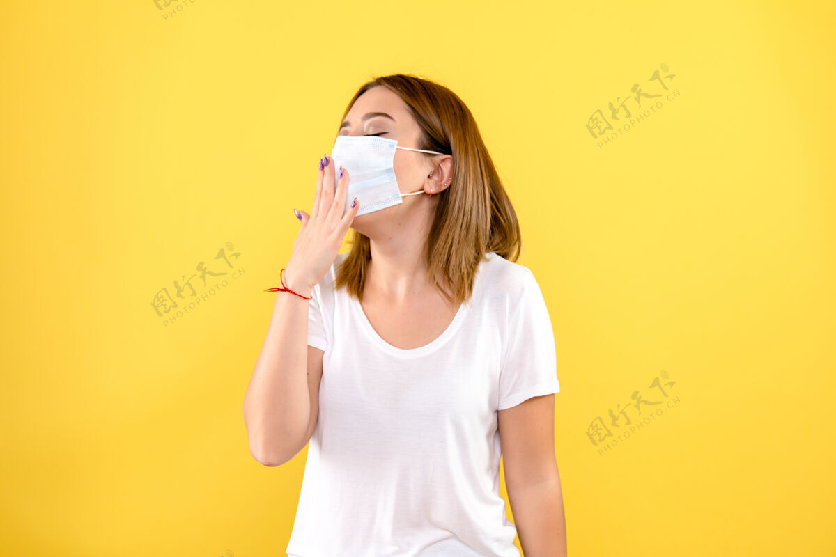 冠状病毒黄墙上戴着面具的年轻女子的正视图正面人面具