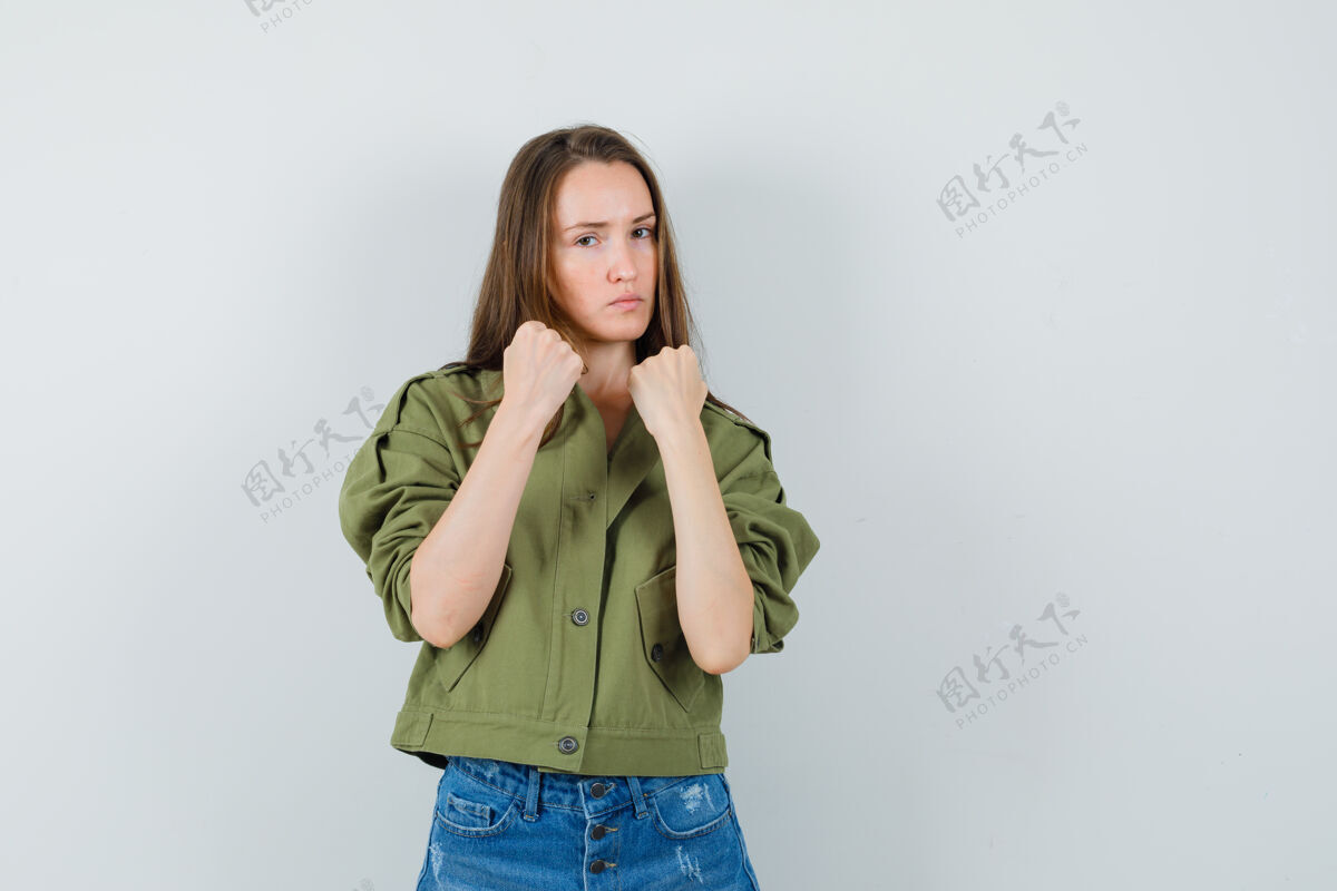 时尚年轻女性穿着夹克 短裤站在打斗姿势 看起来很自信正面视图女人成人时尚