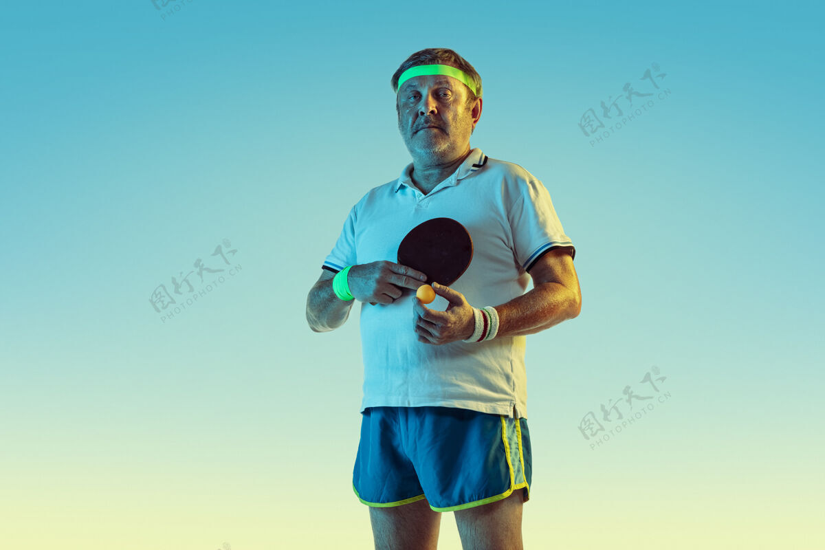 篮球资深男子在霓虹灯下在梯度背景下打乒乓球身材魁梧的白种人男模保持活跃 运动老年人老年人表情