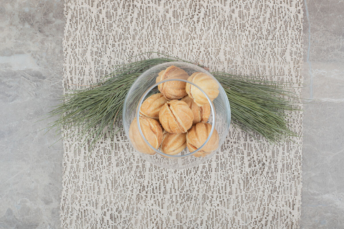 植物胡桃形饼干放在粗麻布上的玻璃碗里高品质照片面包店焦糖甜点