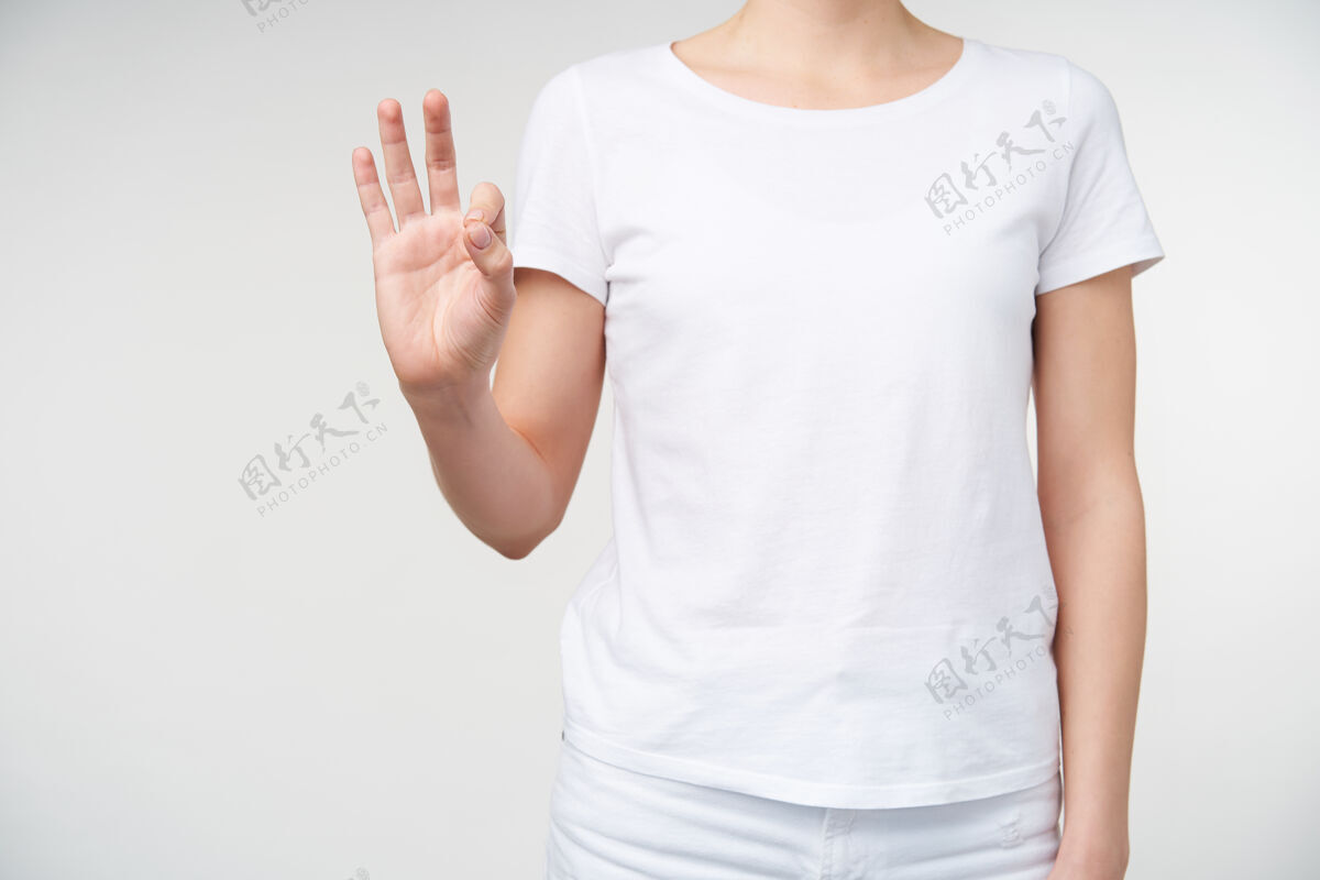 室内摄影棚拍摄的年轻女子举起手 同时用手指形成9号使用歌唱语言 孤立的白色背景在休闲服数字计数符号