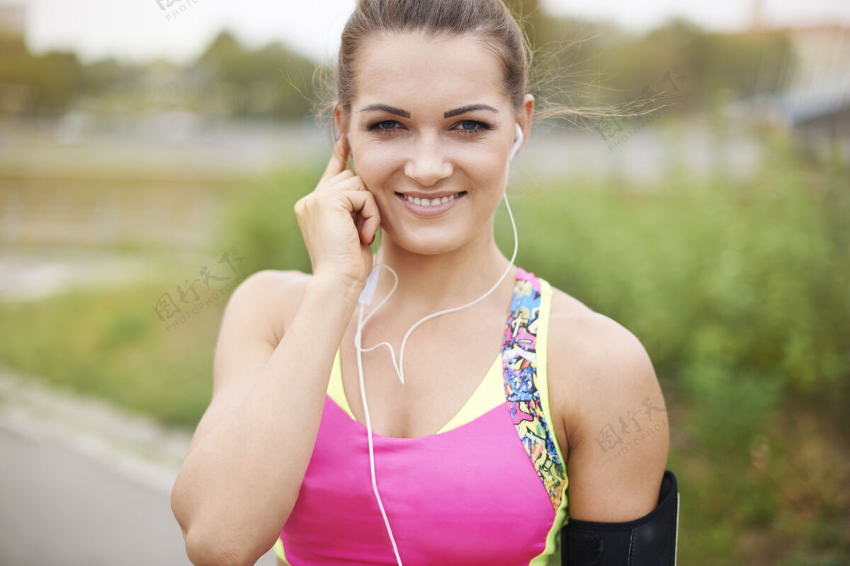 力量年轻女子在户外锻炼慢跑时必须听音乐动作城市场景运动设备