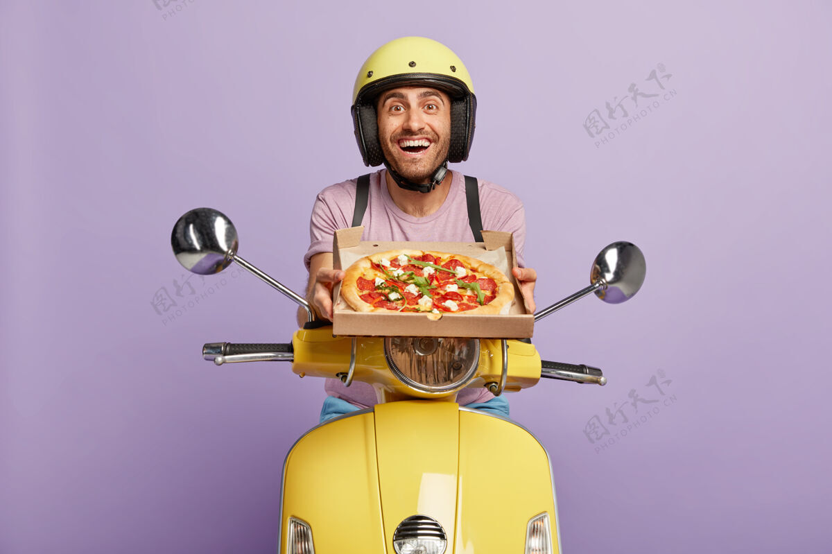 自行车面容友好的送货员一边拿着比萨饼盒一边开着黄色踏板车美味快餐运输