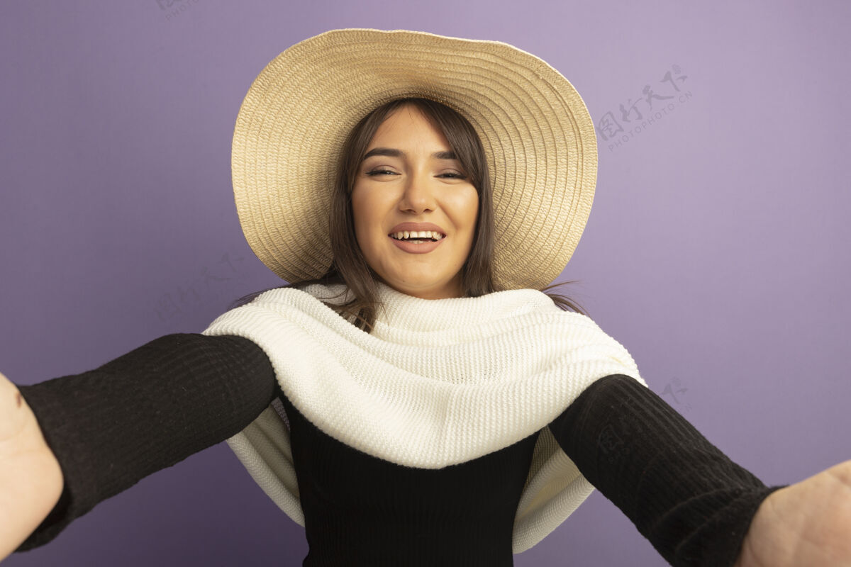 女人戴着白领巾和夏帽的年轻女子用双手做着欢迎的手势 快乐而积极站围巾紫色